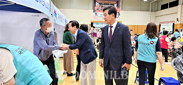 (왼쪽)박현국 군수와 조석현 지구2부총재가 진료대기자와 인사를 나누고있다.