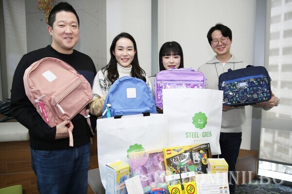 동국제강그룹 임직원이 초등학교 입학 예정 임직원 자녀에 전달할 선물과 함께 기념사진을 촬영하고 있다.